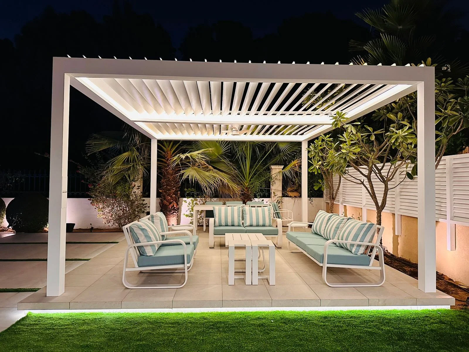 Warmly lit outdoor lounge and landscaping at night