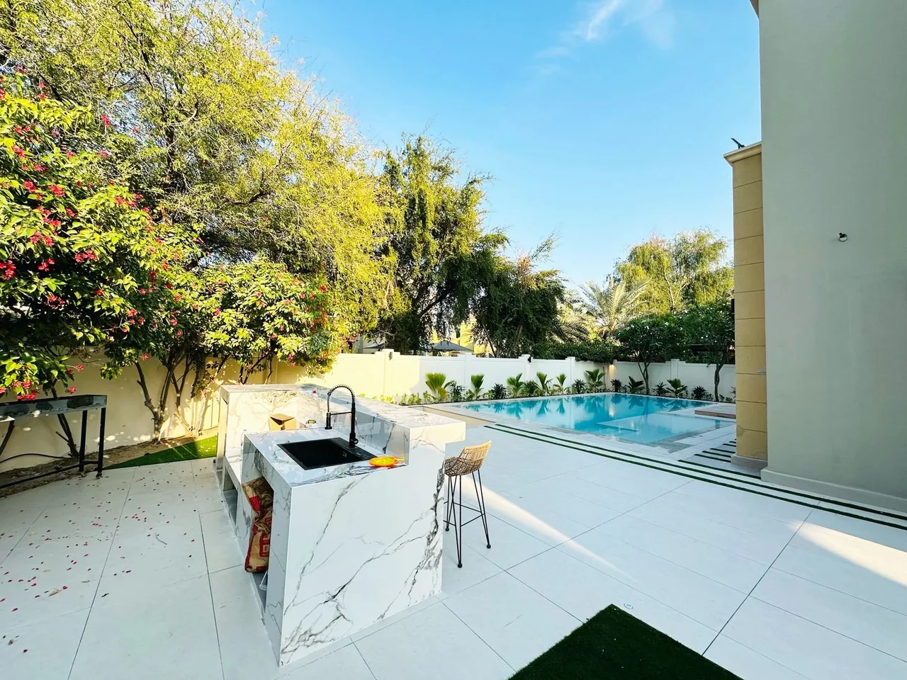 Sunlit swimming pool beside a modern villa